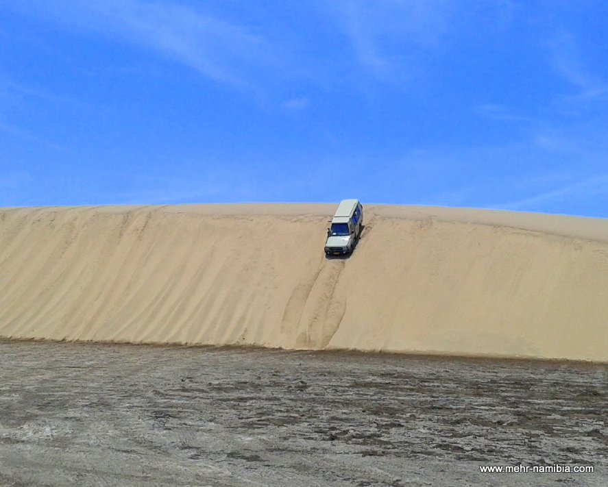 Geländewagen fährt steile Düne hinunter Geländewagen fährt steile Düne hinunter