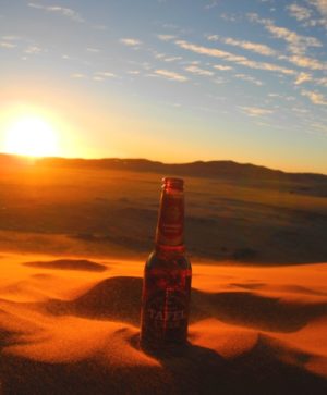 Tafel Lager Bier auf einer Düne im Sonnenuntergang Namibia