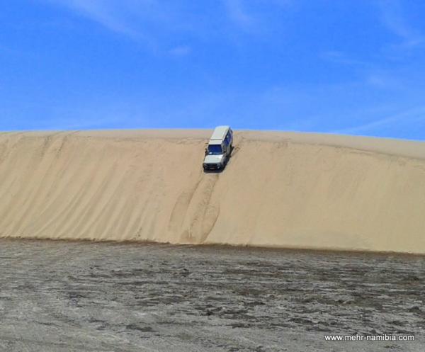 Geländewagen fährt steile Düne hinunter Geländewagen fährt steile Düne hinunter